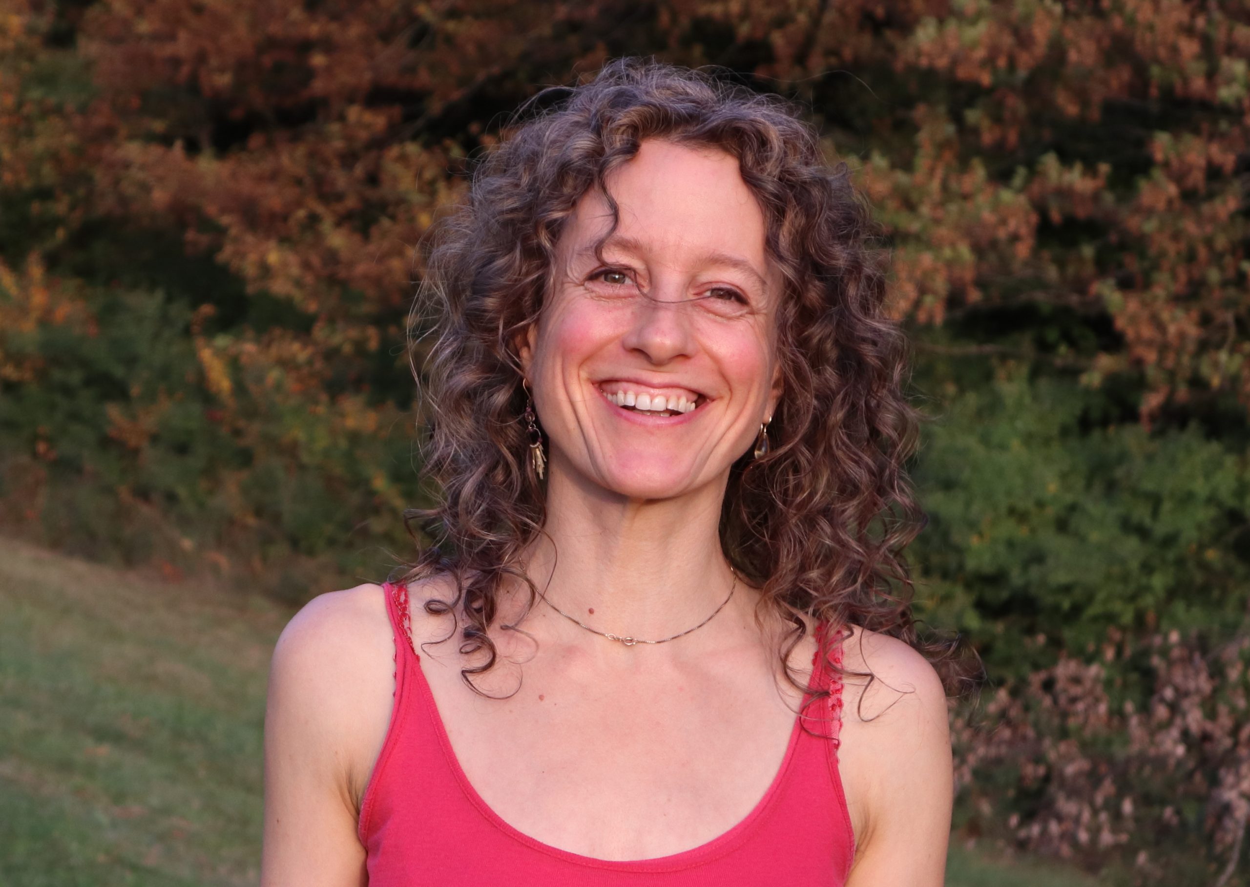 Melanie Ackermann - Hebamme & Massage & Coaching. Frau Ackermann mit einem glücklichen Lachen in der Natur